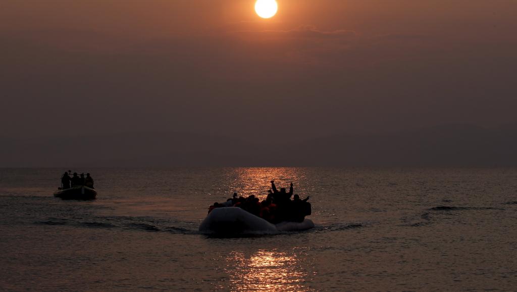 Silhouettes of people in small boats on open water at sunset, warm orange and dark tones, somber mood